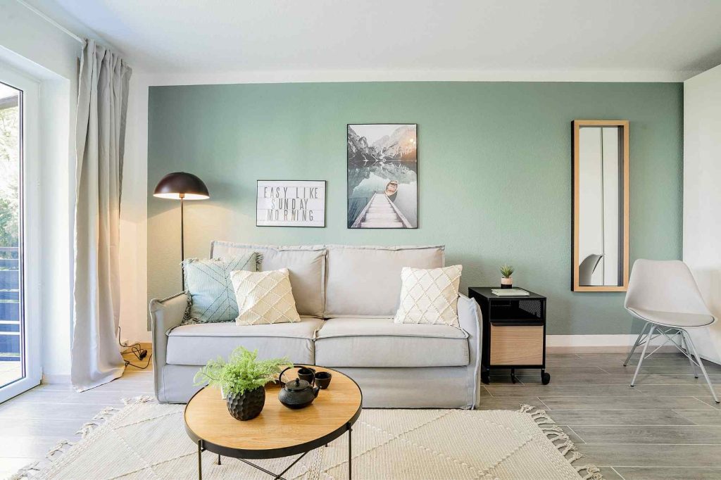 Heike Uhlemann – deine Home Staging Expertin. Auf dem Foto ist ein Beispiel eines Home Stagings zu sehen, in dem eine Akzentfarbe an der Wand genutzt wurde. Die Farbe wird im Raum wiederholt.