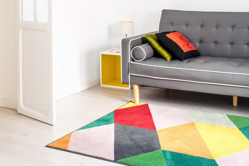 Heike Uhlemann – deine Home Staging Expertin. Auf dem Foto ist ein Beispiel eines Muster-Mix zusehen, mit auffallendem Teppich, für den Mix & Match Einrichtungsstil.